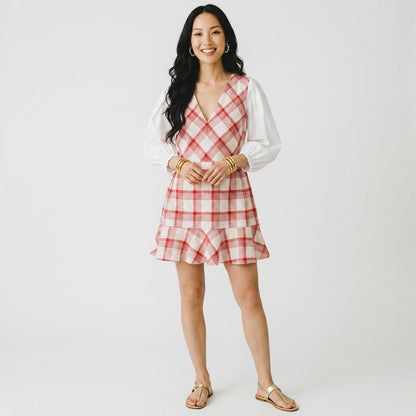Lynn's Closet Boutique model wearing a Tanya Taylor red and cream plaid V-neck dress with white puff sleeves