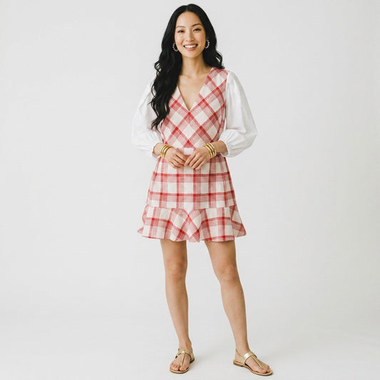 Lynn's Closet Boutique model wearing a Tanya Taylor red and cream plaid V-neck dress with white puff sleeves