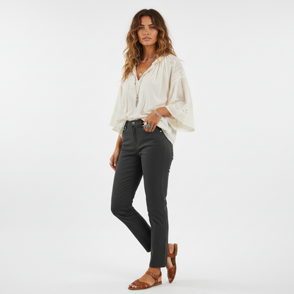 Model wearing Lynn's Closet Boutique Thakoon slate grey cropped jeans with a white bohemian blouse and brown sandals.