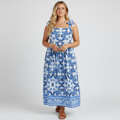 Model wearing a Lynn's Closet Boutique blue and white tile print caftan dress with tie-shoulder straps.