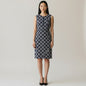 Model wearing a Lynn's Closet Boutique Tory Burch navy sleeveless dress with a white geometric chain print and zip front