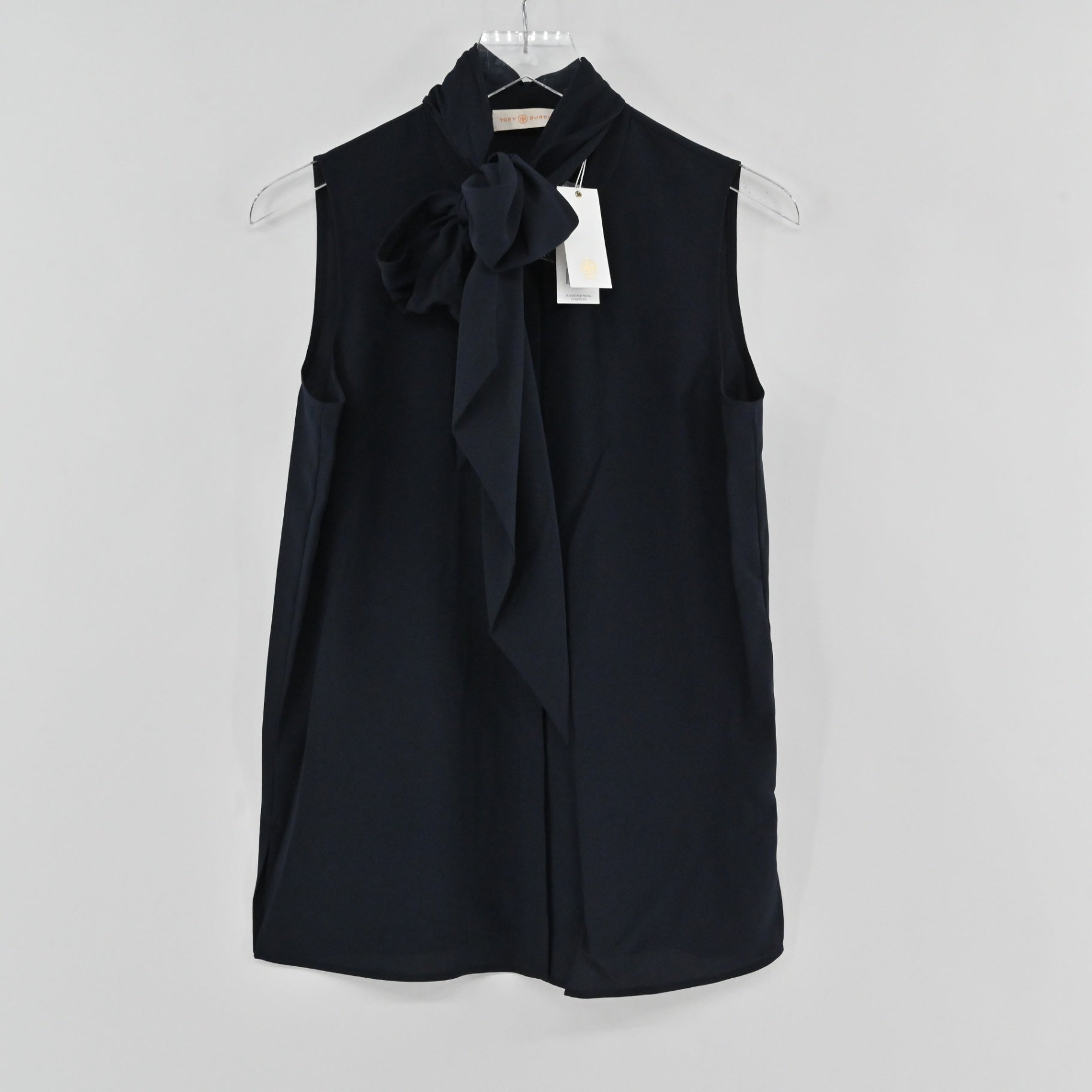 Lynn's Closet Boutique Tory Burch navy sleeveless top featuring a sophisticated tie-neck bow detail on a hanger.