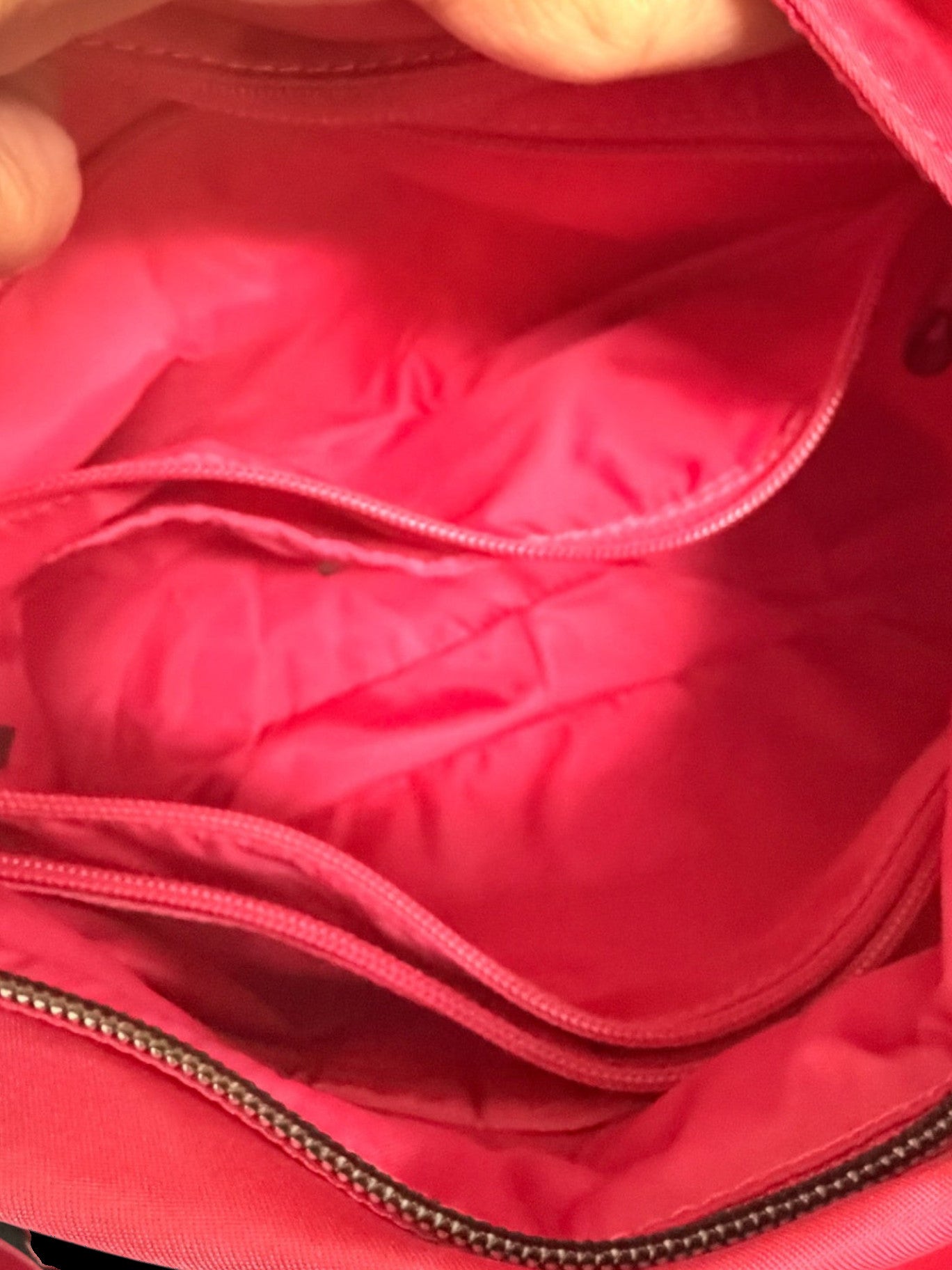 Lynn's Closet Boutique Tumi Voyageur crossbody bag interior showing hot pink nylon lining and zippered compartments.