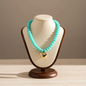 Lynn's Closet Boutique turquoise chunky acrylic bead necklace with a polished gold-tone heart pendant on a display