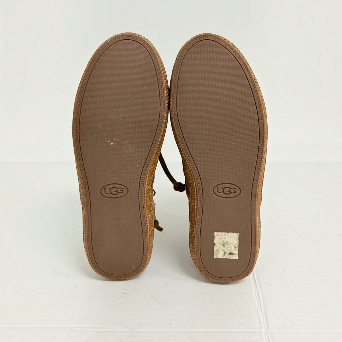 Lynn's Closet Boutique UGG brown suede moccasin boots showing the textured rubber outsoles with brand logo