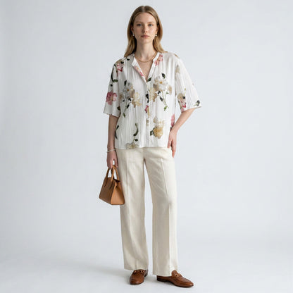 Lynn's Closet Boutique Vince floral blouse with pleated texture, V-neck, and elbow sleeves worn with cream linen pants.