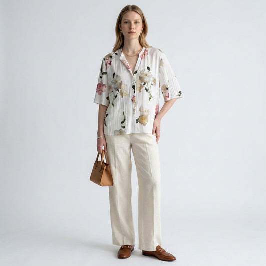 Lynn's Closet Boutique Vince floral blouse with pleated texture, V-neck, and elbow sleeves worn with cream linen pants.