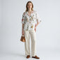 Lynn's Closet Boutique Vince floral blouse with pleated texture, V-neck, and elbow sleeves worn with cream linen pants.