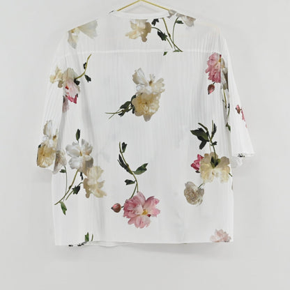 Lynn's Closet Boutique Vince floral top in white with pink and green botanical print, textured fabric, back view.