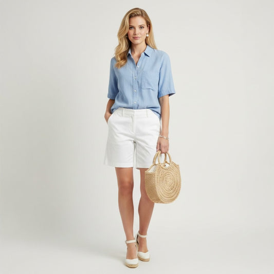 Lynn's Closet Boutique white Bermuda shorts size 6, tailored fit, mid-rise, with pockets. Model wears with blue shirt and espadrilles.