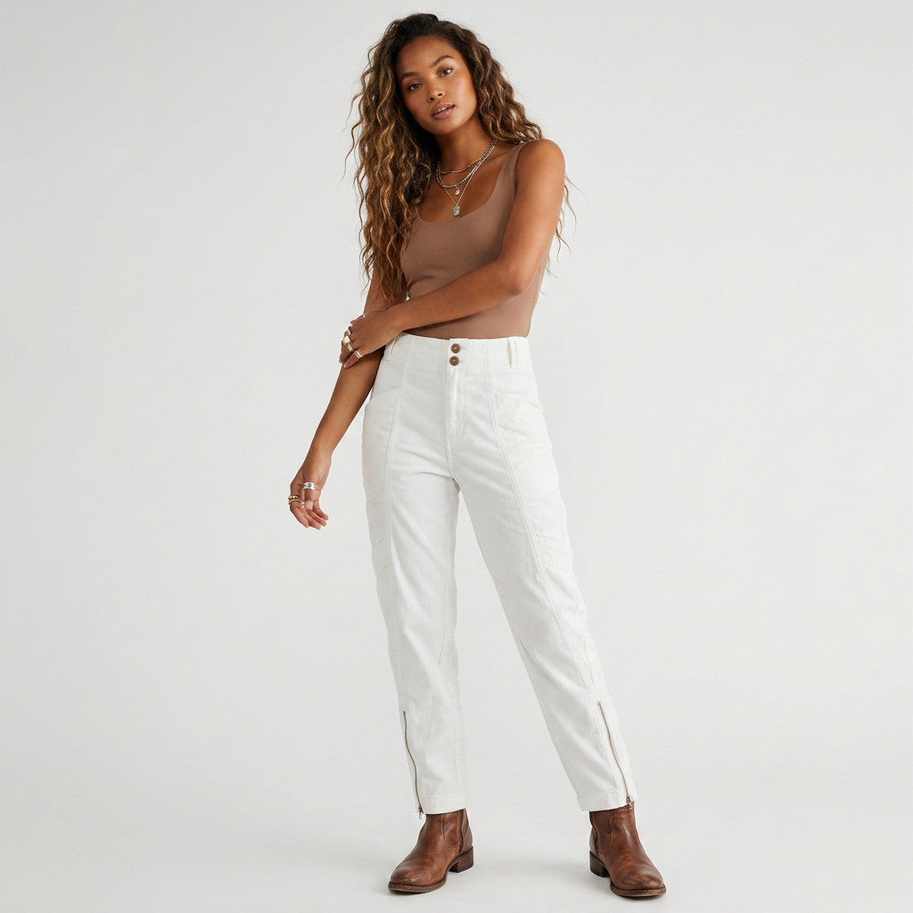 Model wearing Lynn's Closet Boutique white corduroy cargo pants with side zippers and a brown tank top.