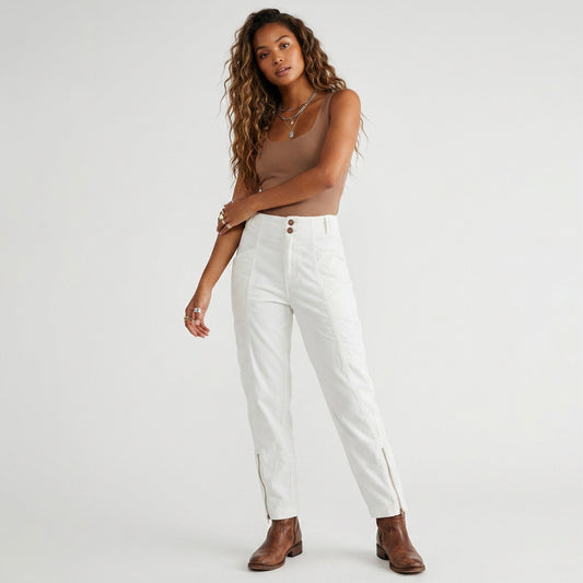 Model wearing Lynn's Closet Boutique white corduroy cargo pants with side zippers and a brown tank top.
