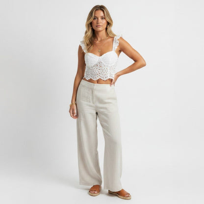 Lynn's Closet Boutique Anthropologie white eyelet cropped corset top with ruffled straps worn with linen trousers