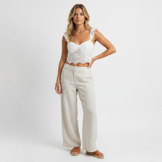 Lynn's Closet Boutique Anthropologie white eyelet cropped corset top with ruffled straps worn with linen trousers