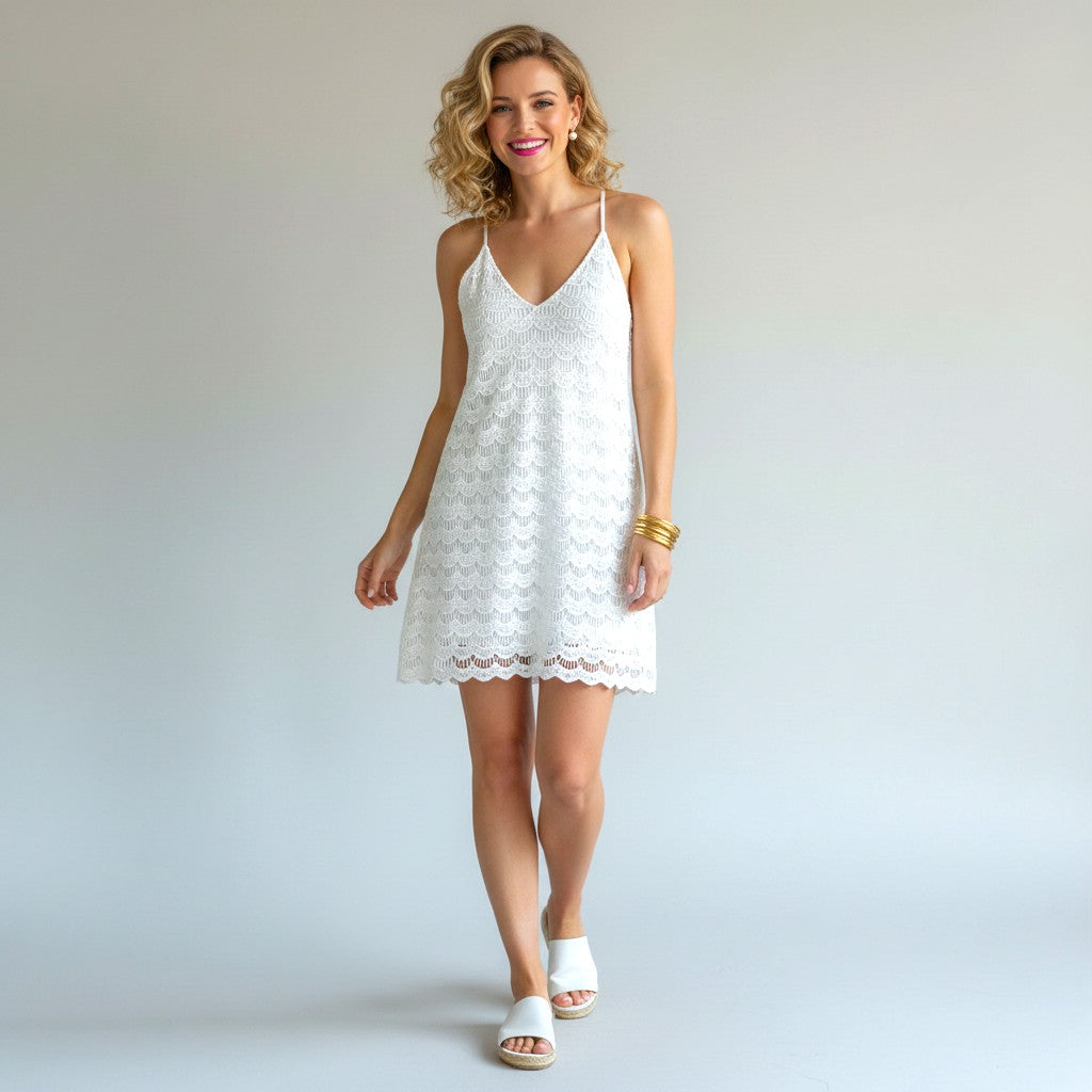 Lynn's Closet Boutique white eyelet lace mini dress with spaghetti straps and scalloped hem. Model is wearing size L.