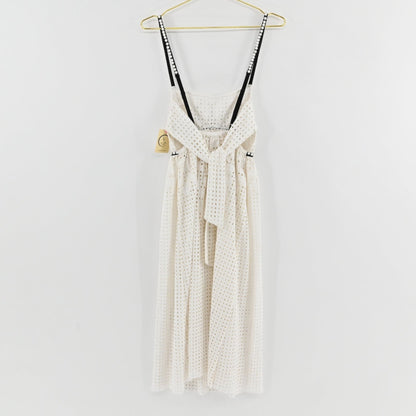 Lynn's Closet Boutique white eyelet midi dress with black pearl-embellished straps and back tie detail on a hanger.