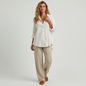 Lynn's Closet Boutique Free People white eyelet button-down shirt worn by a model with beige linen trousers