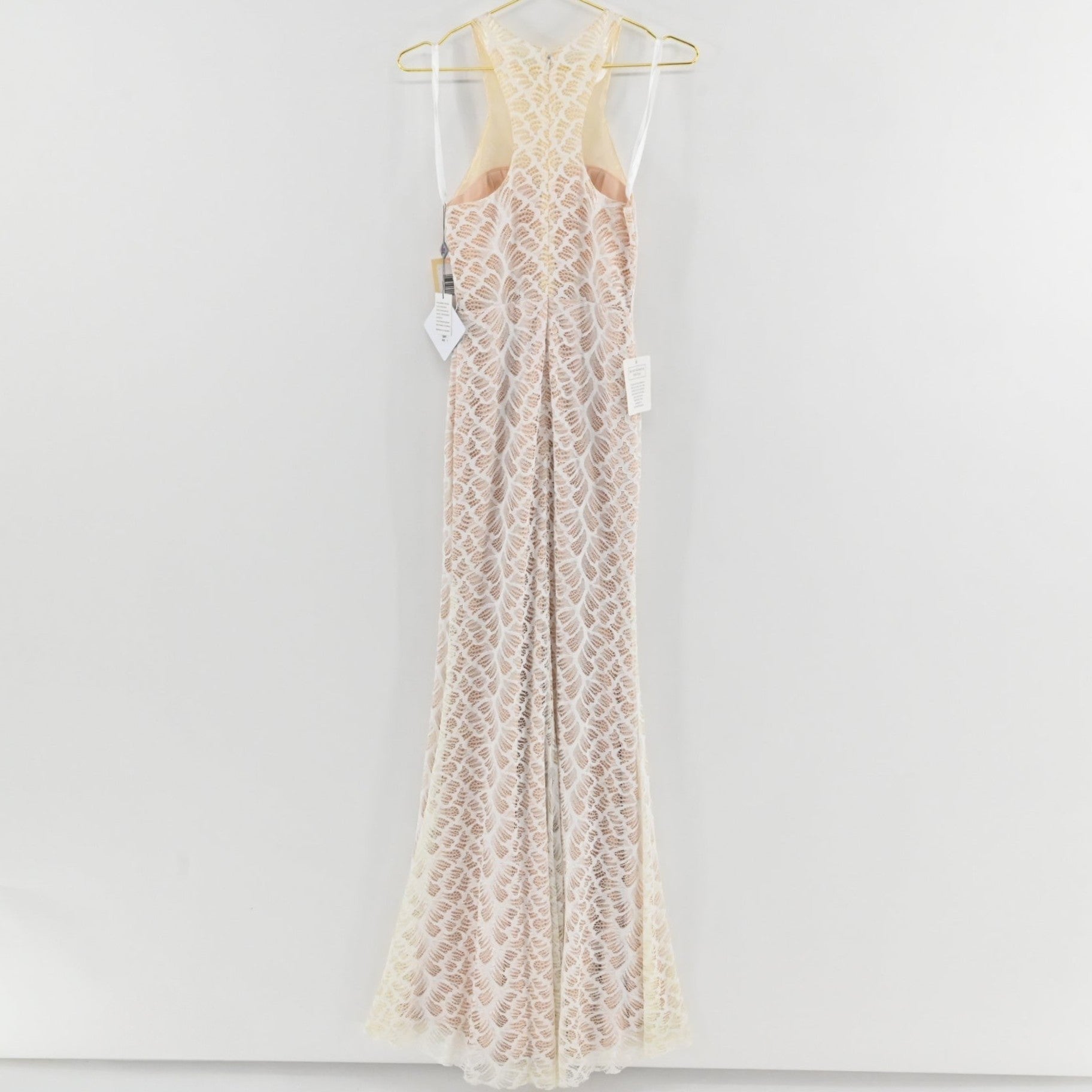 Lynn's Closet Boutique Glow Colors white floor-length lace gown with racerback and leaf-patterned overlay on hanger