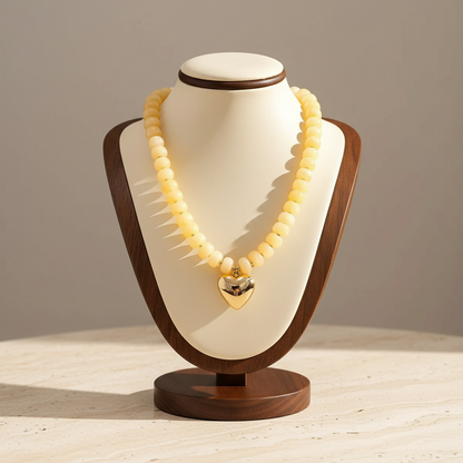Lynn's Closet Boutique chunky yellow acrylic bead necklace with a polished gold-tone heart pendant on a display bust.