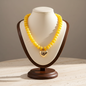 Lynn's Closet Boutique yellow chunky acrylic bead necklace with a polished gold-tone heart pendant on a display bust