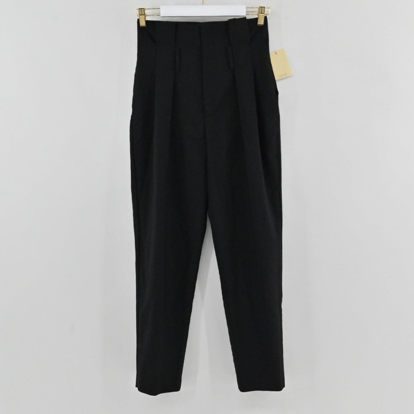 Lynn's Closet Boutique Anine Bing black high-waisted tapered trousers with front pleats hanging on a hanger.