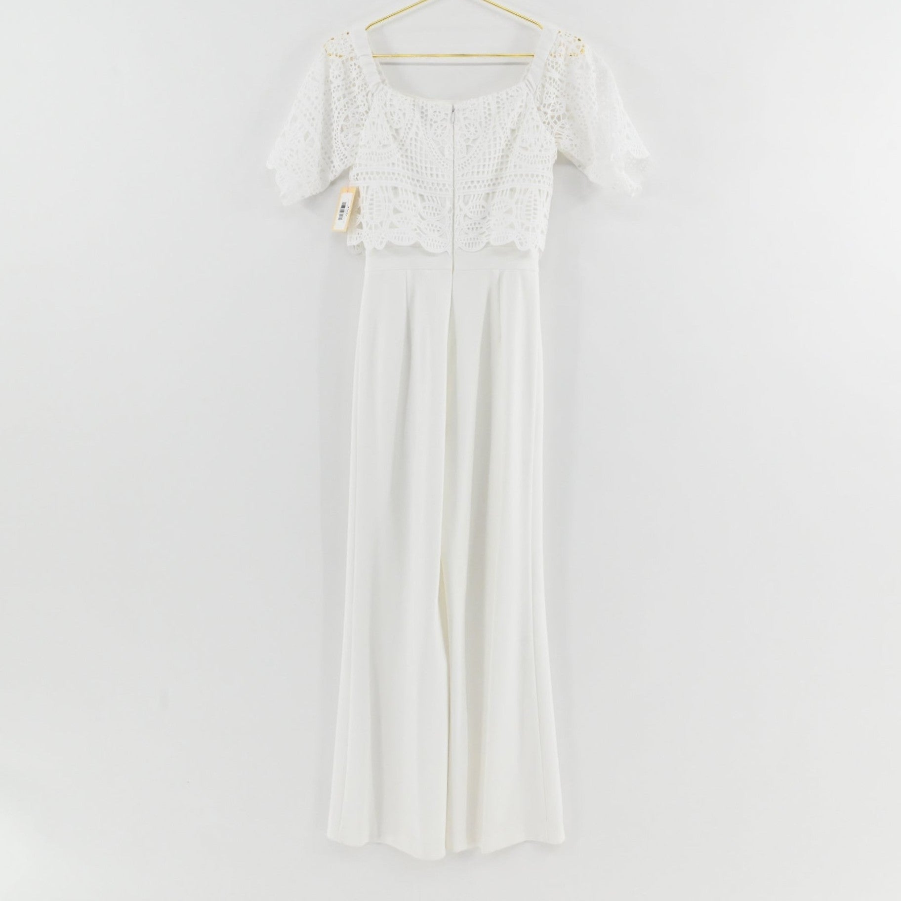 Lynn's Closet Boutique Antonio Melani white jumpsuit with off-the-shoulder crochet lace bodice and wide-leg trousers.