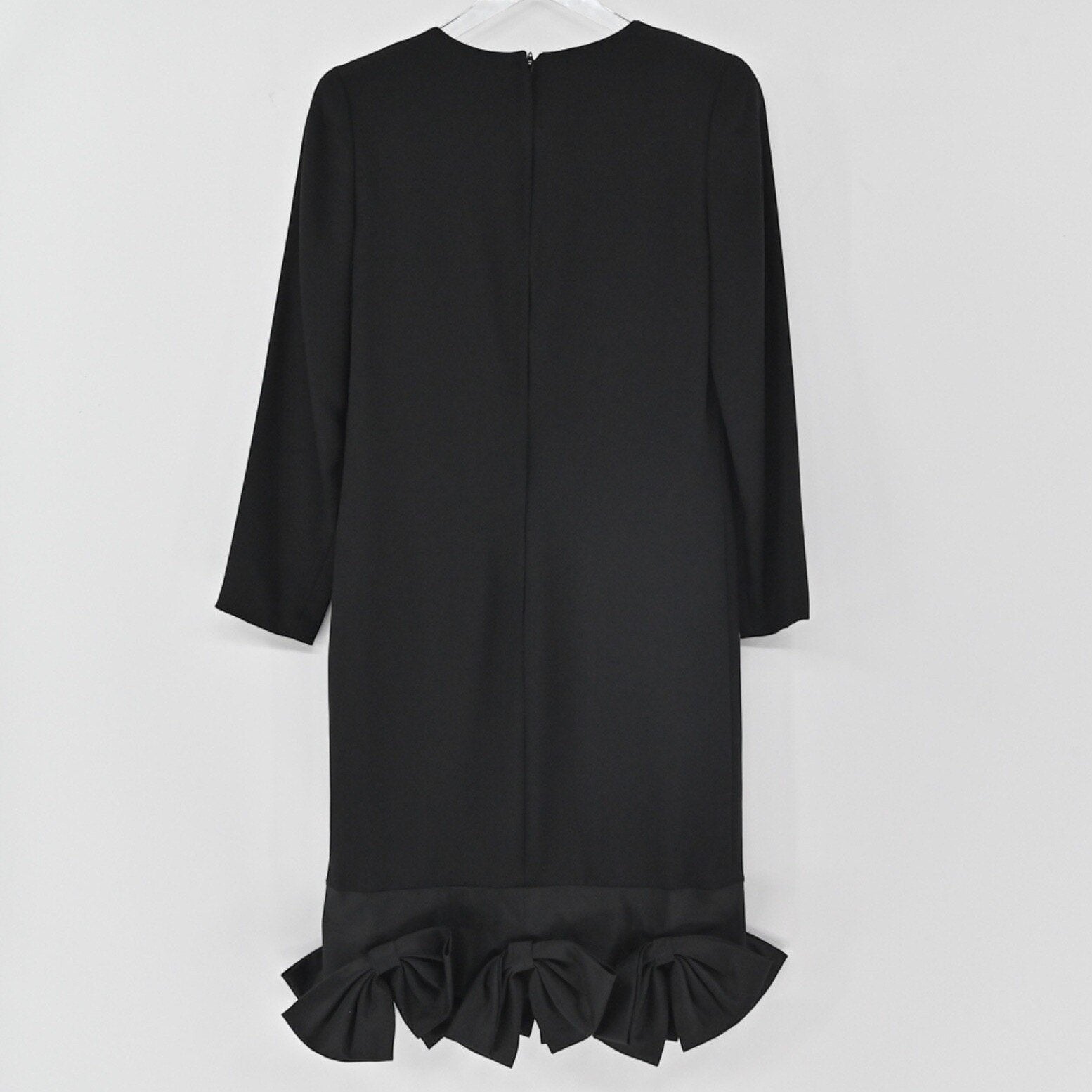 Lynn's Closet Boutique black long-sleeve shift dress featuring a structured bow hemline on a white background