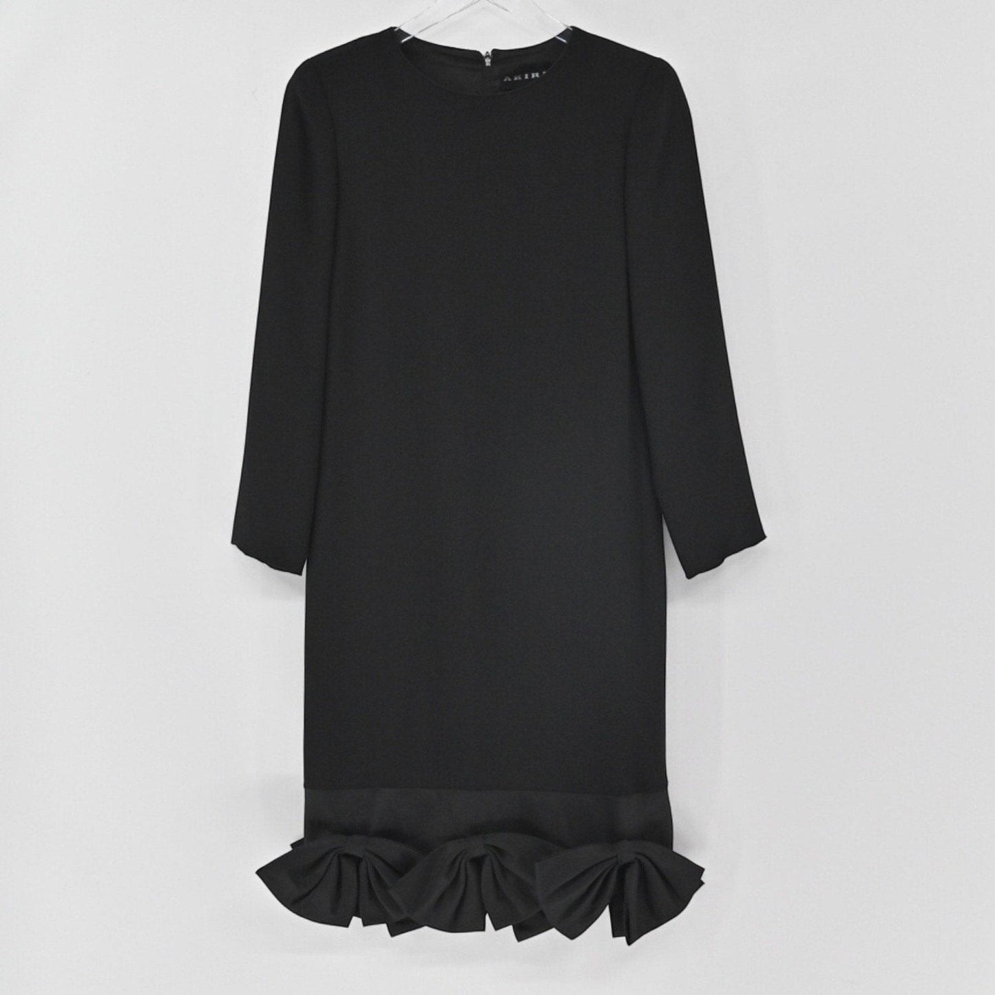 Lynn's Closet Boutique black long-sleeve shift dress featuring a round neckline and structured bows along the hem.