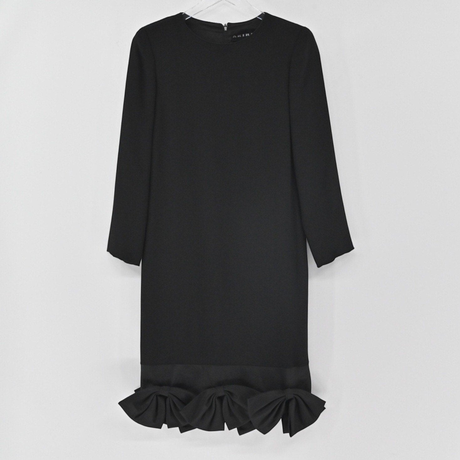 Lynn's Closet Boutique black long-sleeve shift dress featuring a round neckline and structured bows along the hem.