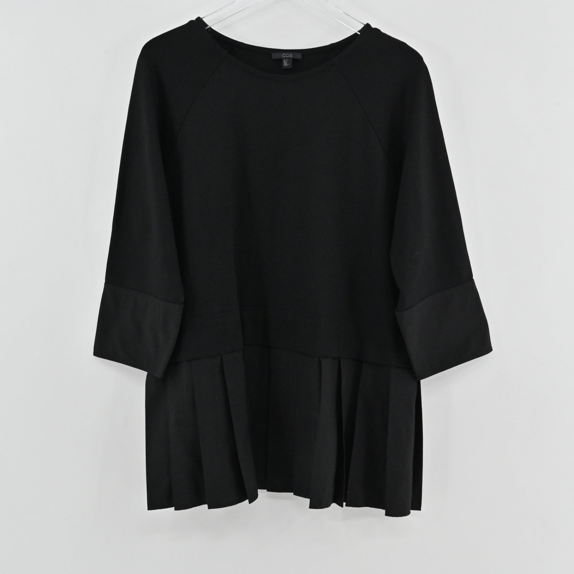 Lynn's Closet Boutique black COS peplum top with round neck and three-quarter raglan sleeves on a hanger.
