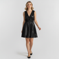 Model wearing a Lynn's Closet Boutique black faux leather mini dress with a V-neck, ruffle trim, and elastic waist.