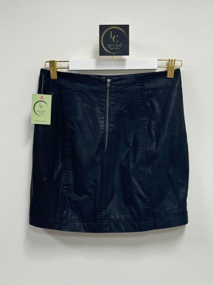Lynn's Closet Boutique black faux leather mini skirt with exposed back zipper and panel detailing hanging on a hanger