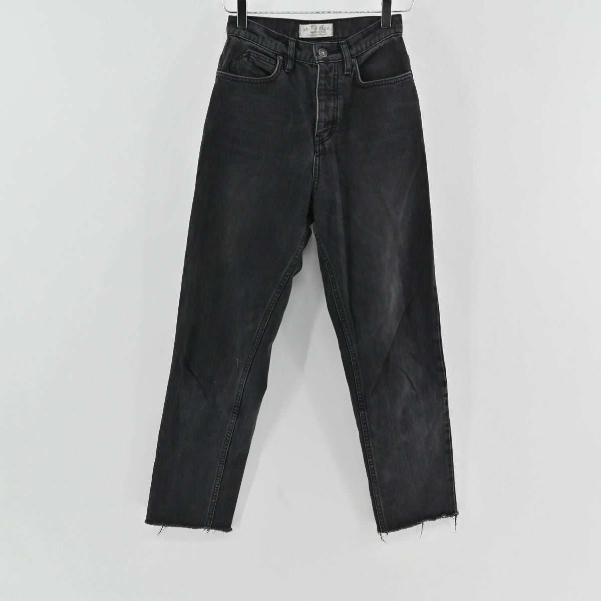 Lynn's Closet Boutique Free People high-rise straight-leg jeans in a black wash with a button-fly and raw frayed hem.