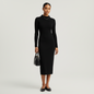Model wearing a Lynn's Closet Boutique black long-sleeve midi dress with an asymmetrical collar and knit texture.
