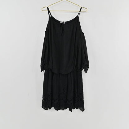 Lynn's Closet Boutique black cold-shoulder dress with lace trim and spaghetti straps hanging on a gold hanger