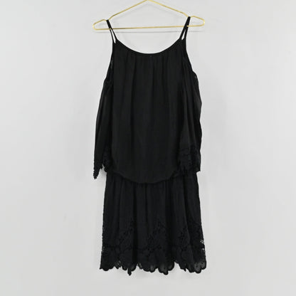 Lynn's Closet Boutique black cold-shoulder dress with delicate lace trim on sleeves and hem hanging on a gold hanger