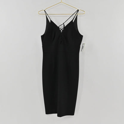 Lynn's Closet Boutique black midi dress with spaghetti straps and lace-up front detail hanging on a gold hanger
