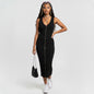 Model wearing a black ribbed AllSaints Alicia midi dress with a front zipper from Lynn's Closet Boutique