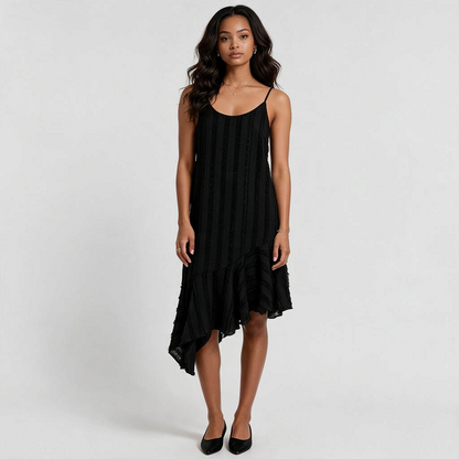Model wearing a black Lynn's Closet Boutique Anthropologie Eri + Ali slip dress with an asymmetrical ruffle hem.