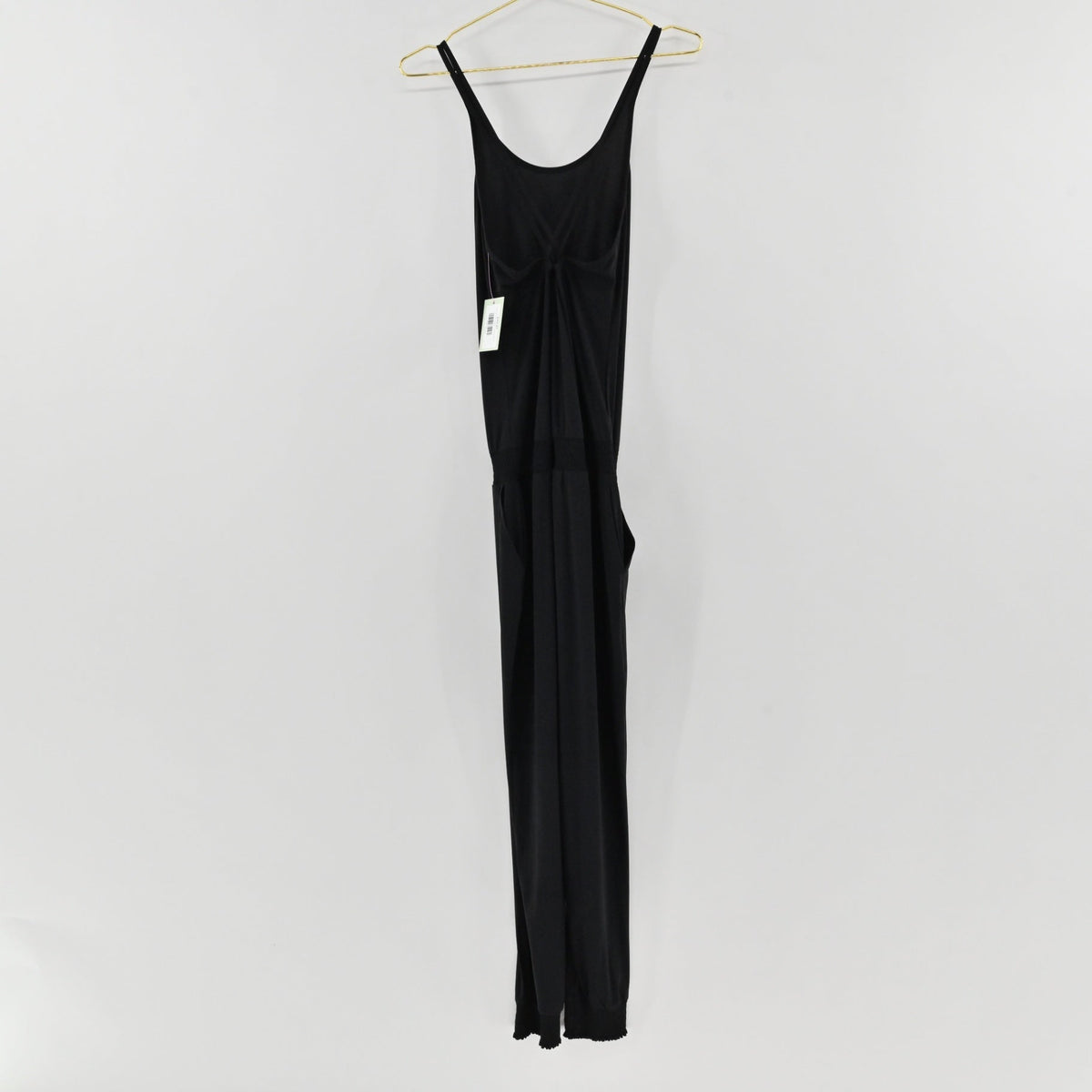 Lynn's Closet Boutique black Sweaty Betty strappy jumpsuit with a scoop back and jogger cuffs hanging on a hanger.