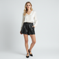 Lynn's Closet Boutique black vegan leather paperbag shorts worn by a model with a white blouse and black heels