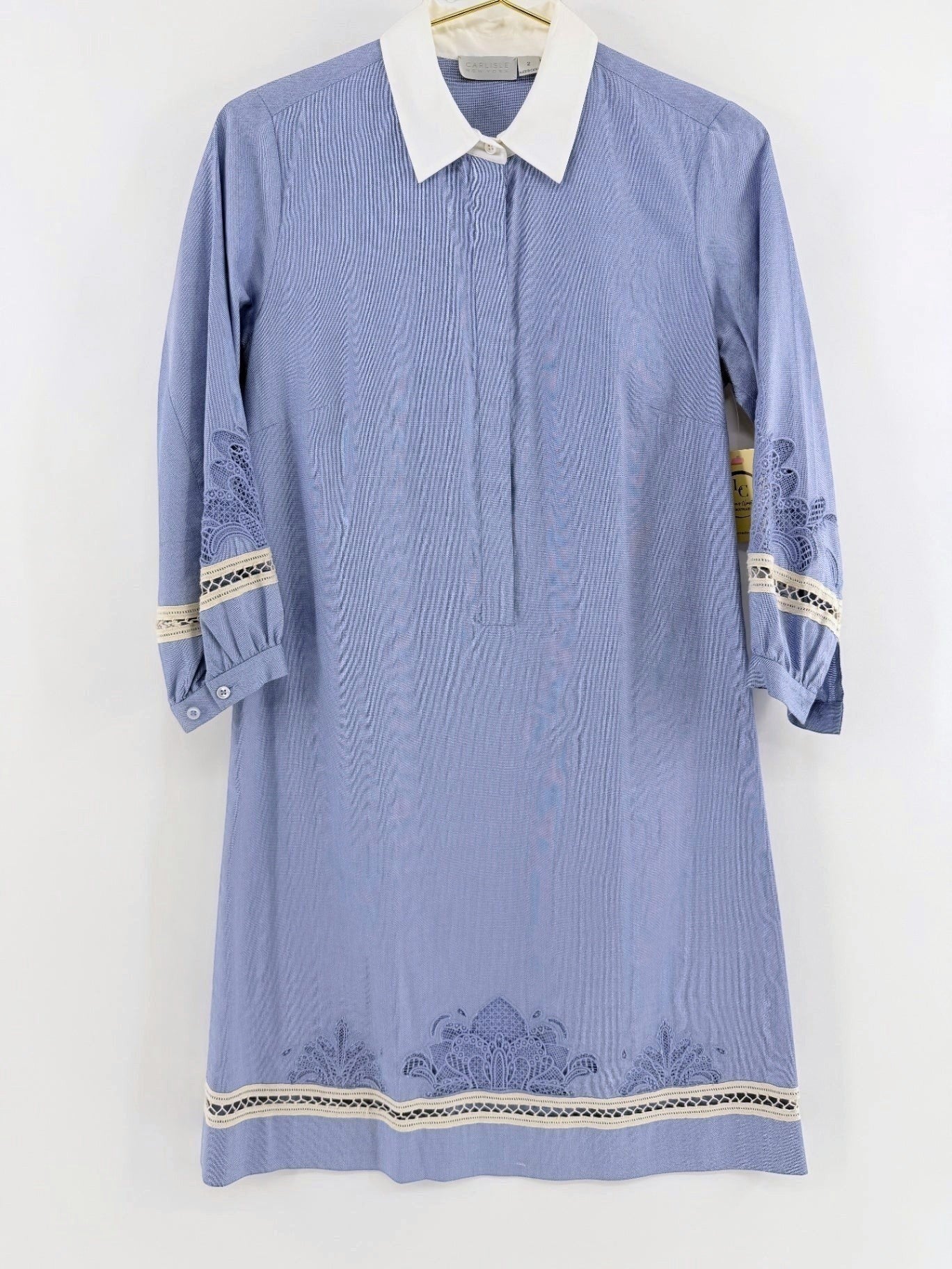 Lynn's Closet Boutique blue chambray dress with white collar, lace trim, and intricate embroidery on sleeves and hem.