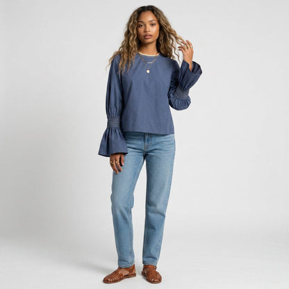 Lynn's Closet Boutique blue cotton top with voluminous bell sleeves and smocked cuffs worn by a model with jeans.