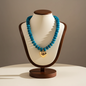 Lynn's Closet Boutique chunky blue acrylic bead necklace with a polished gold-tone heart pendant on a display stand.
