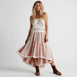 Model wearing a Lynn's Closet Boutique Free People boho high-low skirt with floral patchwork in cream and red tones.