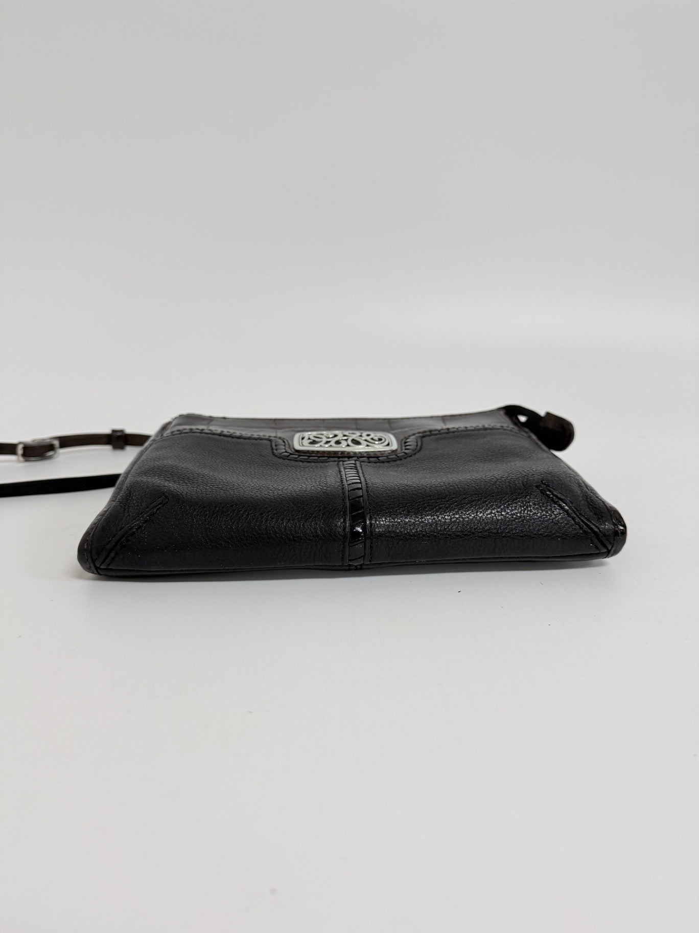 Lynn's Closet Boutique Brighton crossbody bag in black and brown textured leather with a silver-tone metal emblem.