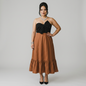 Model wearing a Lynn's Closet Boutique strapless midi dress with a black bodice, brown skirt, and oversized bow detail.