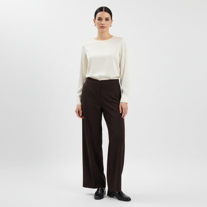 Model wearing Lynn's Closet Boutique Eileen Fisher brown wide-leg knit pants with a cream blouse and black loafers.