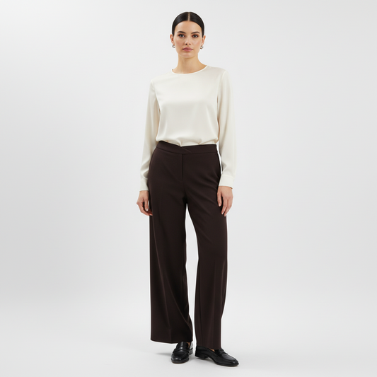 Model wearing Lynn's Closet Boutique Eileen Fisher brown wide-leg knit pants with a cream blouse and black loafers.
