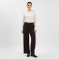 Model wearing Lynn's Closet Boutique Eileen Fisher brown wide-leg knit pants with a cream blouse and black loafers.